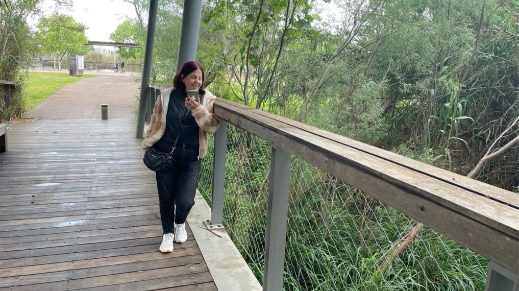 גשר שחוצה את נחל הדר מצדו השני של השביל ומול הגשר החוצה את האגם בפארק